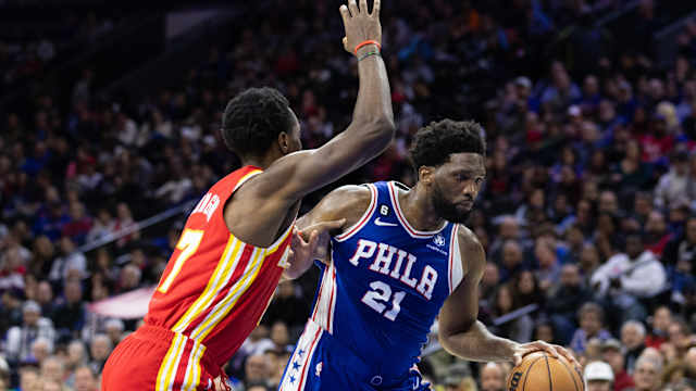 76ers center Joel Embiid dribbles past Hawks forward Onyeka Okongwu.